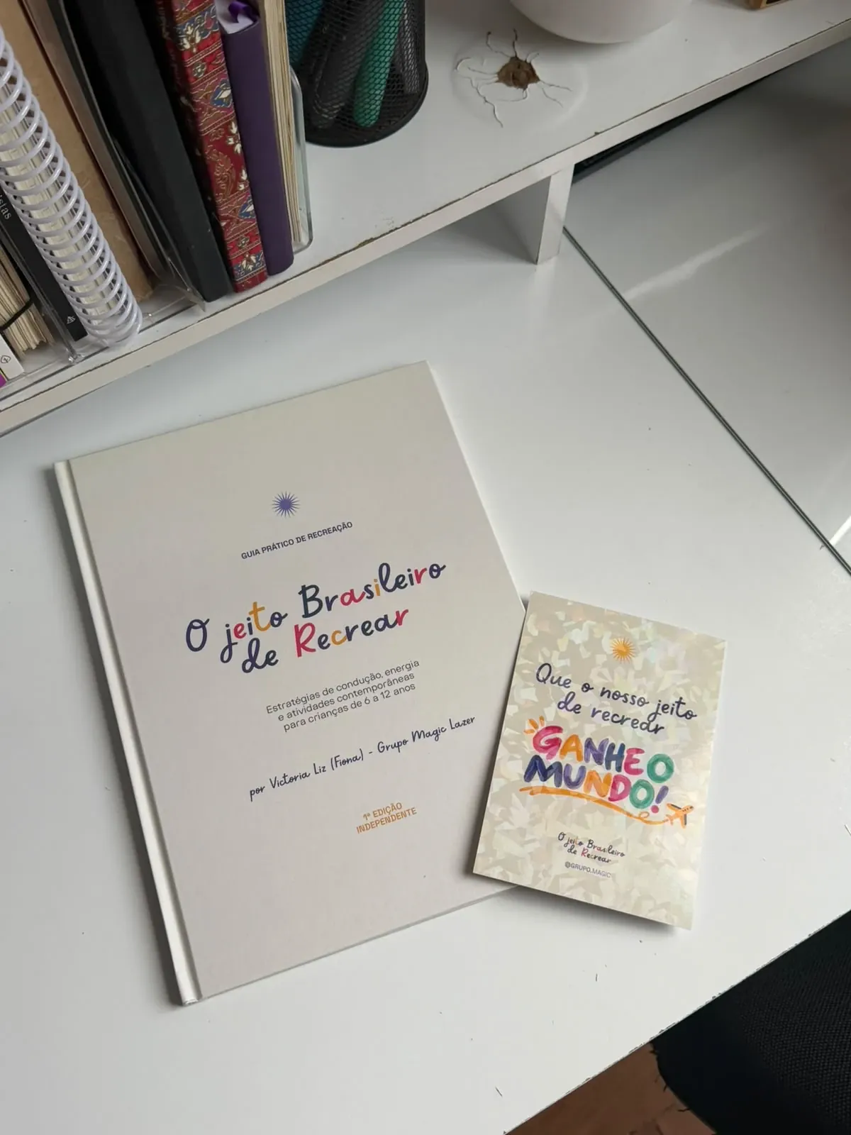 O Jeito Brasileiro de Recrear sobre a mesa, ao lado do cartão “Que o nosso jeito de recrear ganhe o mundo”